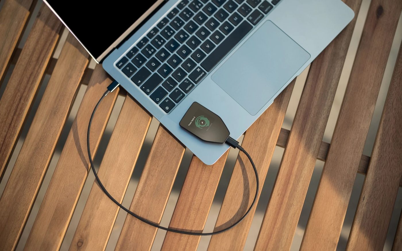 Trezor Safe 5 hardware wallet connected to a laptop